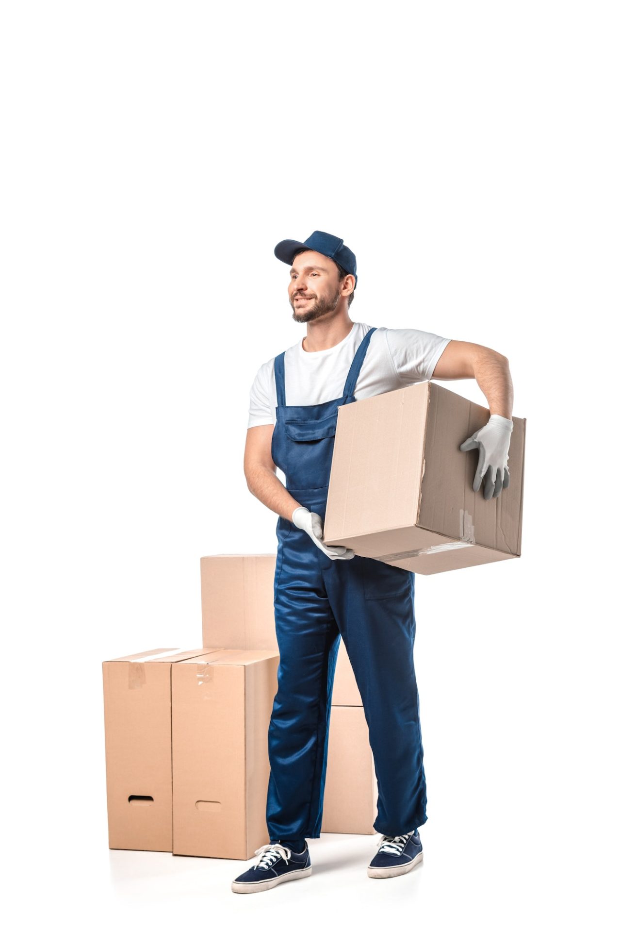 handsome mover in uniform carrying cardboard box isolated on white